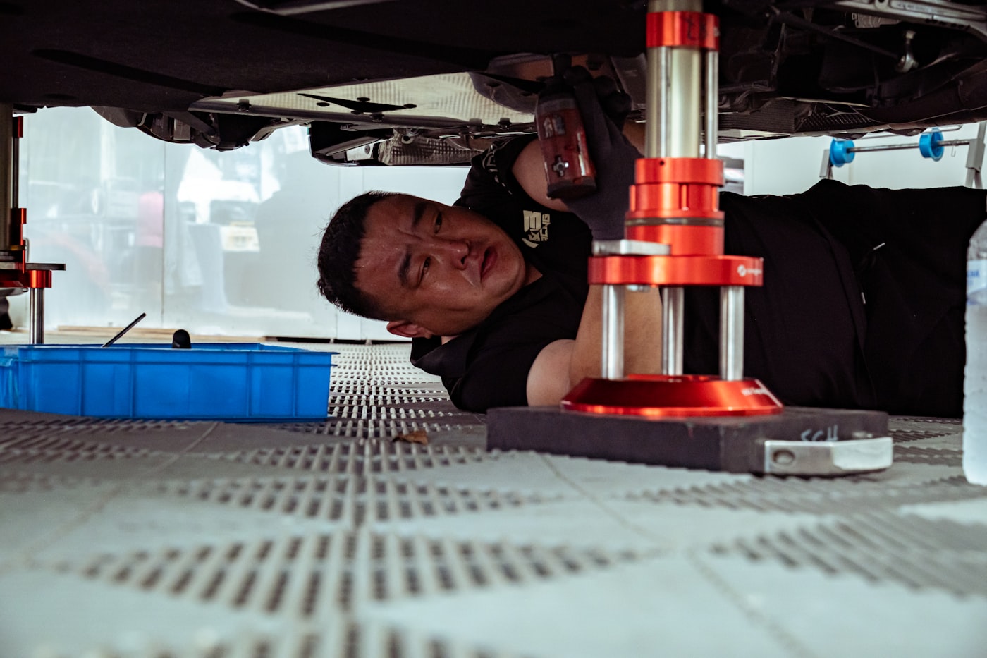A mechanic working underneath a car on a garage floor