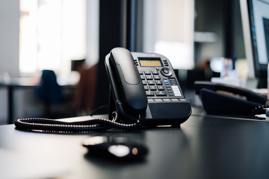 A desk telephone on a dark wooden table